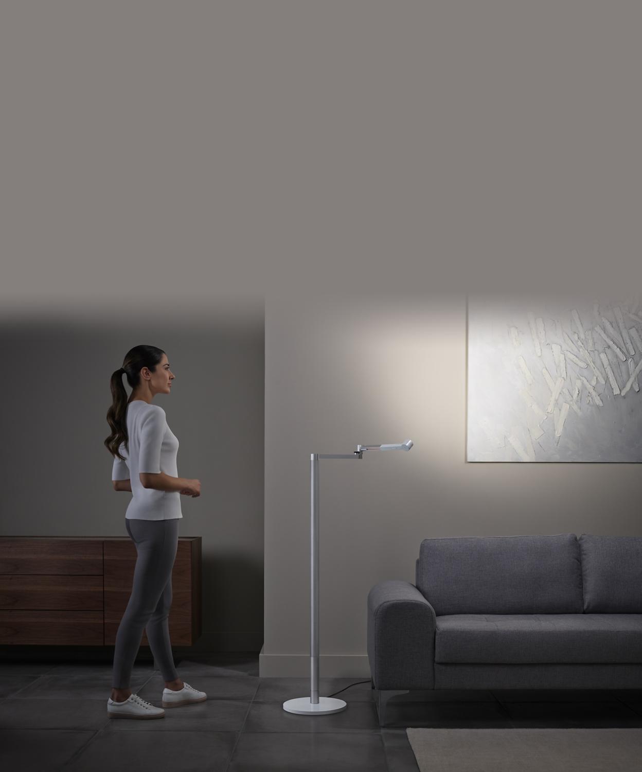 Vrouw die kunst bewondert die wordt verlicht door krachtige accentverlichting van de Dyson Solarcycle Morph lamp